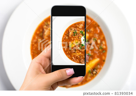 Smartphone camera hand point shoot photo soup. Food photograph. Made for social networks. 81393034
