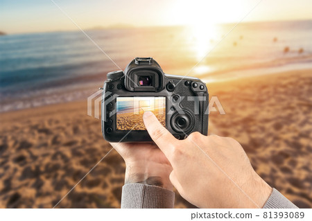 Digital single-lens reflex camera in hands. Man photographer makes photos. Male hands hold the camera close-up 81393089
