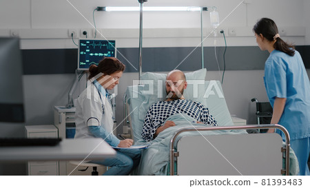 Black nurse checking patient vitals monitoring heart rate injecting vitamin Black nurse checking patient vitals monitoring heart rate injecting vitamin 81393483