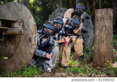 Paintball players aiming outdoors Paintball players aiming outdoors 81396650