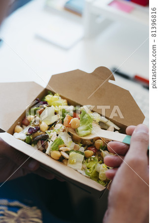 man sitting at his desk eats a chickpea salad man sitting at his desk eats a chickpea salad 81396816