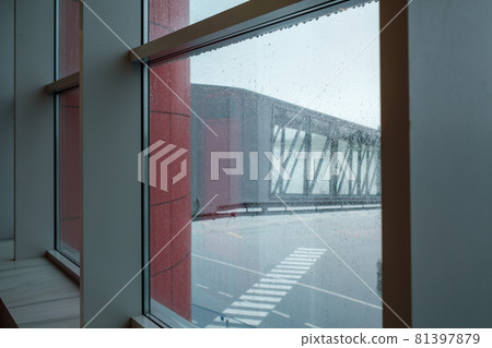 Jet bridge behind airport window Jet bridge behind airport window 81397879