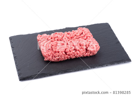 Ground beef on black slate stone board isolated on white background. Ground beef on black slate stone board isolated on white background. 81398285