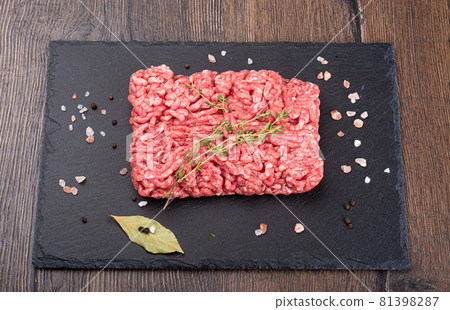 Minced meat with a sprig of caraway seeds and spices on a black slate stone board. 81398287