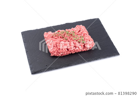 Minced meat with caraway seeds on black slate stone board isolated on white background. 81398290