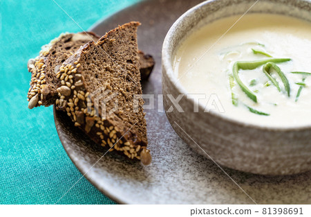 Clay bowl of Finnish salmon cream soup served with leek and croutons on green tablecloth background. Healthy food concept. Food background with copy space. Close up, selective focus. Clay bowl of Finnish salmon cream soup served with leek and croutons on green tablecloth background. Healthy food concept. Food background with copy space. Close up, selective focus. 81398691