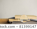 Open book and a magnifying glass over the light wall. 81399147