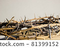 A cross with thorn crown on a wooden table.  81399152