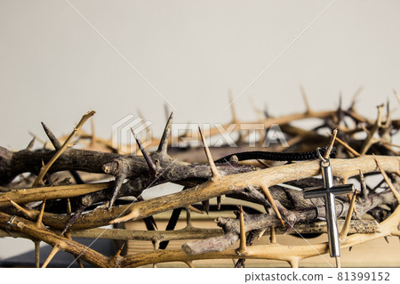 A cross with thorn crown on a wooden table. A cross with thorn crown on a wooden table. 81399152