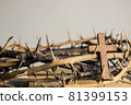 A wooden cross with thorn crown on a wooden table.  81399153