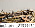 A wooden cross with thorn crown on a wooden table.  81399154