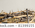 A thorn crown with nail on a wooden table.  81399155