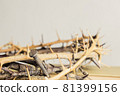 A thorn crown with nail on a wooden table.  81399156