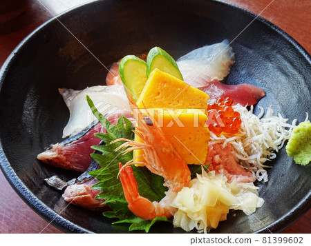 Bowl of rice topped with sashimi  81399602