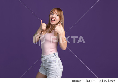 Portrait of young beautiful girl isolated on purple studio background. Concept of human emotions, facial expression, youth, sales, ad. Portrait of young beautiful girl isolated on purple studio background. Concept of human emotions, facial expression, youth, sales, ad. 81401896