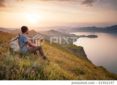 Young man travels alone on the backdrop of the mountains Young man travels alone on the backdrop of the mountains 81402247