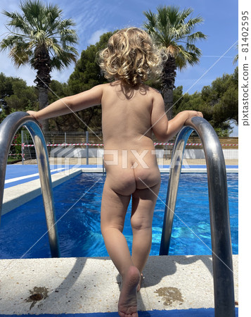 Rear view of girl by swimming pool Rear view of girl by swimming pool 81402595