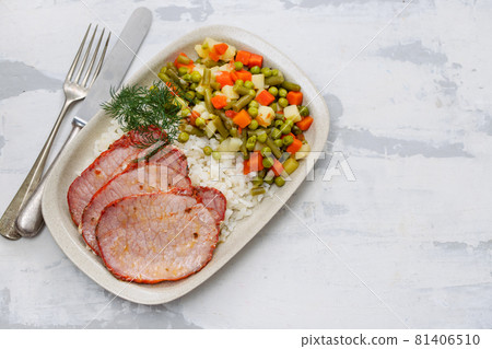 fried pork with boiled rice and vegetables on dish 81406510