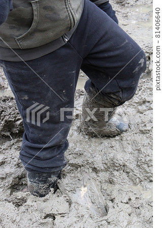 Closeup of a child walking in thick mud 81406640