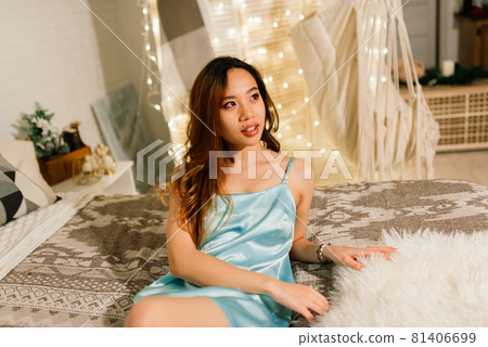 Beautiful young asian woman celebrating christmas at home, having fun while opening presents Beautiful young asian woman celebrating christmas at home, having fun while opening presents 81406699