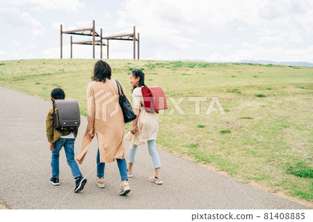 Parent and child walking on the road (back view) 81408885