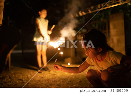 Children enjoying fireworks on the porch of the house 81409909