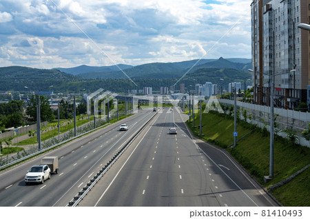 Multi-lane highway with a dividing strip. Automobile city road on a summer day. 81410493
