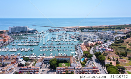 A view from the sky of the tourist Portuguese town of Vilamoura, with Yachts and sailboats moored in the port on the dock. A view from the sky of the tourist Portuguese town of Vilamoura, with Yachts and sailboats moored in the port on the dock. 81410752