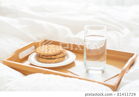 Tray with water and crackers dbreakfast on a bed Tray with water and crackers dbreakfast on a bed 81411729