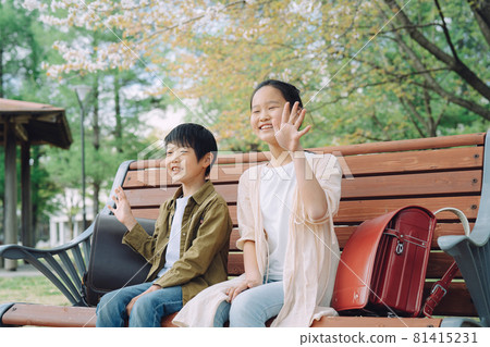 坐在長凳上的小學生(揮手) 坐在長凳上的小學生(揮手) 81415231