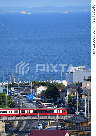 Keikyu 2100 series that crosses the prefectural road Yokosuka Hayama Line with Tokyo Bay in the background Keikyu 2100 series that crosses the prefectural road Yokosuka Hayama Line with Tokyo Bay in the background 81418140