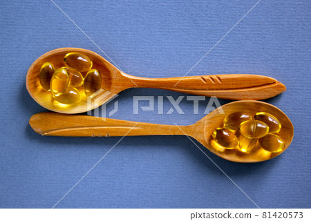 Medical concept. Wooden spoons with pills isolated on beautiful blue background. Web banner with a copy space. Medical concept. Wooden spoons with pills isolated on beautiful blue background. Web banner with a copy space. 81420573