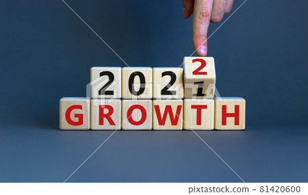 Planning 2022 growth new year symbol. Businessman turns a wooden cube and changes words 'Growth 2021' to 'Growth 2022'. Beautiful grey background, copy space. Business, 2022 growth new year concept. 81420600