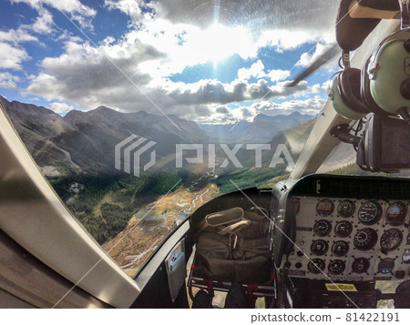 Inside of cockpit a helicopter flying over Rocky mountains in national park Inside of cockpit a helicopter flying over Rocky mountains in national park 81422191