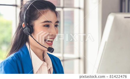 Businesswoman wearing headset working actively in office 81422476