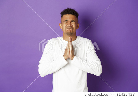 Image of desperate african-american guy pleading to God, holding hands in pray and begging for something, making wish, standing worried and asking for help Image of desperate african-american guy pleading to God, holding hands in pray and begging for something, making wish, standing worried and asking for help 81423438