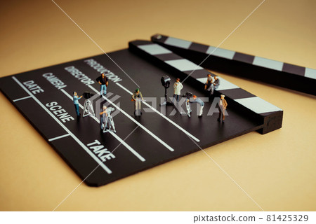 Movie making process. Crew figurines on a wooden clapper Movie making process. Crew figurines on a wooden clapper 81425329