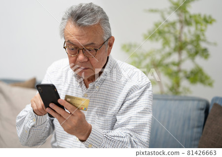 Smartphone credit card senior man 81426663