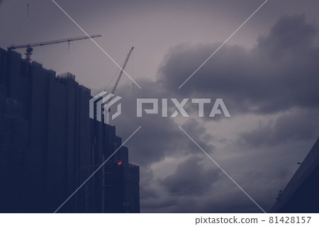 Unfinished huge building stop continues to construct at the time of depression economy. Concept of bankrupt and money problems construction business with dark grey clouds and sky in background Unfinished huge building stop continues to construct at the time of depression economy. Concept of bankrupt and money problems construction business with dark grey clouds and sky in background 81428157