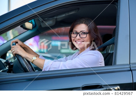 Middle-aged woman driver with glasses, female driving a car. Middle-aged woman driver with glasses, female driving a car. 81429567