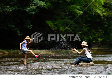 Parents and children playing in the river 81429612
