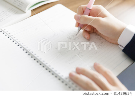 Hands of a high school girl who is tired of studying and scribbling 81429634