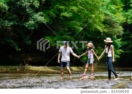 A family holding hands and crossing the river A family holding hands and crossing the river 81430039