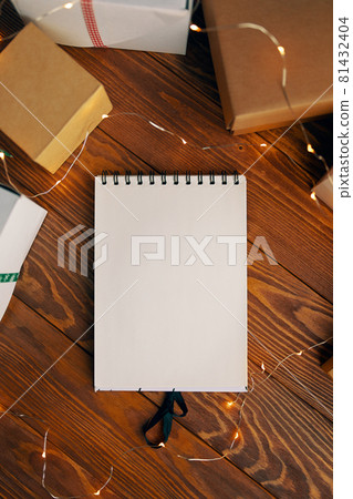 Flat lay of blank notebook and gift boxes on wood table background. Flat lay of blank notebook and gift boxes on wood table background. 81432404