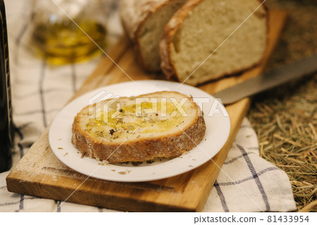 Healthy vegan breakfast concept. Whole wheat bread with olive oil. Sliced bread on wooden table. Hay Healthy vegan breakfast concept. Whole wheat bread with olive oil. Sliced bread on wooden table. Hay 81433954