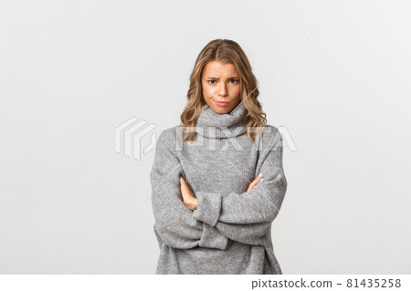 Image of disappointed gloomy girl, frowning and standing defensive, feeling offended or upset, standing over white background 81435258