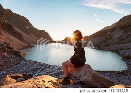 Adventurous Caucasian Adult Woman Hiking on top of a Canadian Rocky Mountain 81435356