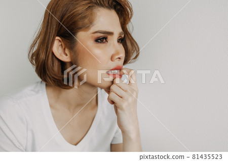 Woman is biting her nails alone in her apartment. 81435523