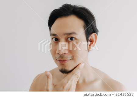 Happy man show off his face apply skincare product. 81435525