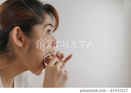 Close up face of woman bite a piece of bread on white background. 81435527